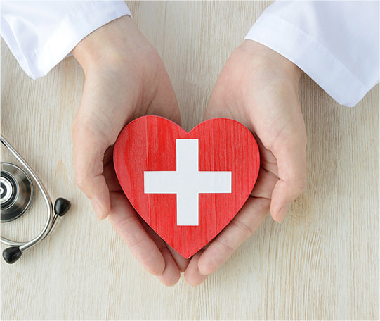 ハートの赤十字の飾りをのせた手